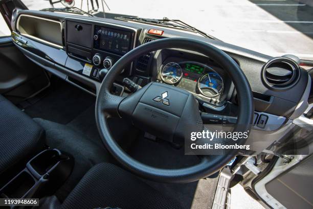 Logo sits on the streering wheel inside the cab of an electric Mitsubishi Fuso Truck & Bus Corp. Truck during the launch of AB InBev Africa's...