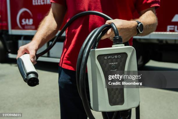 Worker displays an e-fuso charging pack for an electric Mitsubishi Fuso Truck & Bus Corp. Truck during the launch of AB InBev Africa's renewable...