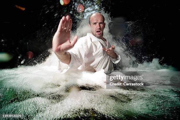 karate man practicing in a river waterfall. - 空手 ストックフォトと画像