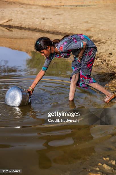 indian young girl collecting potable water from the lake, desert village, india - asia village river stock pictures, royalty-free photos & images