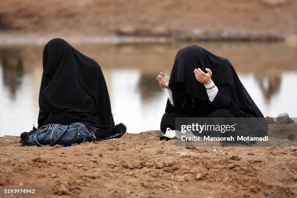 iranian muslim women praying outdoors - iraqi woman - fotografias e filmes do acervo