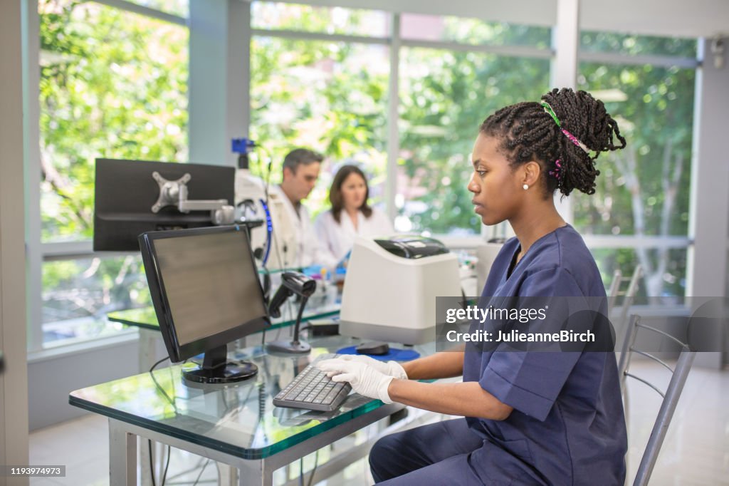 Young African Lab Technician Working At Desktop Pc High-Res Stock Photo ...