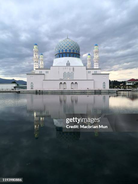 beautiful reflection of mosque at sunrise in kota kinabalu, sabah, east malaysia - kota kinabalu stock-fotos und bilder