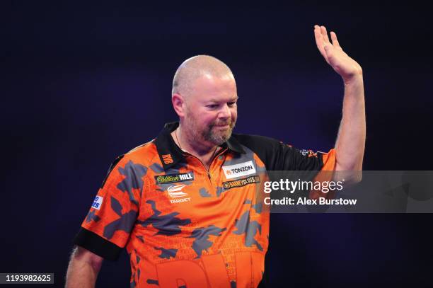 Raymond van Barneveld of The Netherlands waves to the fans as he walks off the stage after loosing his First Round match against Darin Young of The...
