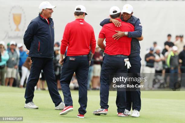 Patrick Reed of the United States team is congratulated by Playing Captain Tiger Woods of the United States team, Assistant Captain Zach Johnson of...