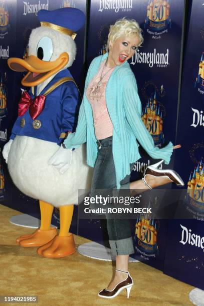 Singer Christina Aguilera arrives with Disney character Donald Duck for Disneyland's 50th anniversary party at the Disneyland theme park in Anaheim,...