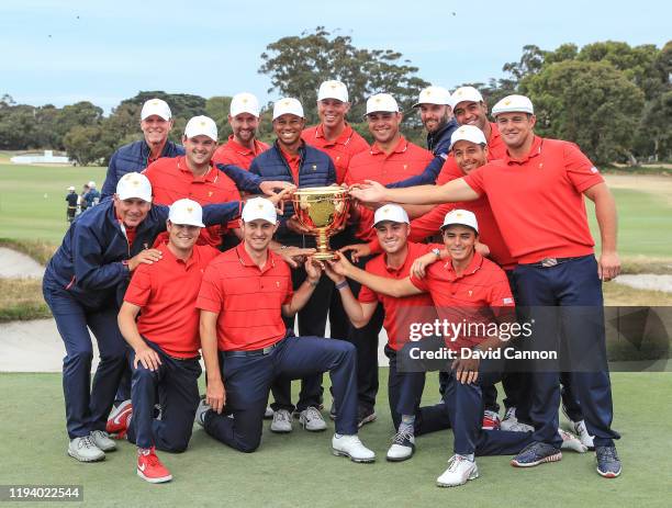 Tiger Woods the captain of the United States Team holds the Presidents Cup with his team after he had led his team to a 16-14 victory in the final...