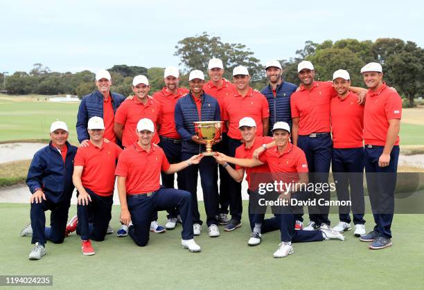 Tiger Woods the captain of the United States Team holds the Presidents Cup with his team after he had led his team to a 16-14 victory in the final...