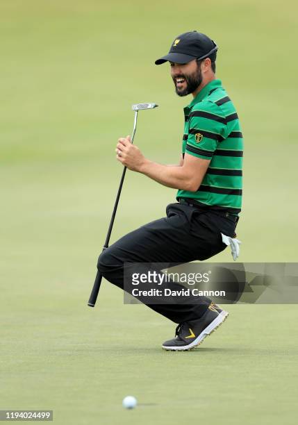 Adam Hadwin of the International Team sinks to his knees as his putt to win his match against Bryson De Chambeau slips by on the 18th hole during the...
