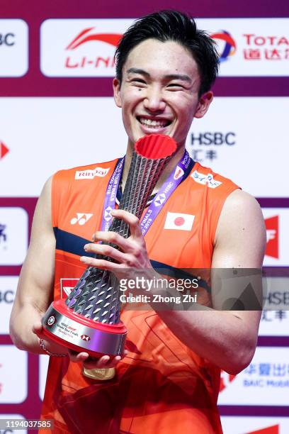 Kento Momota of Japan reacts with trophy during award ceremony after winning the men's singles final match against Anthony Sinisuka Ginting of...