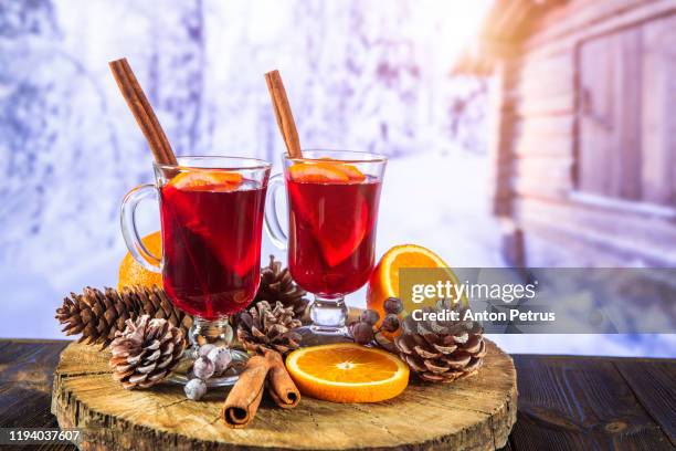 two glasses of hot mulled wine with spices on the background of a winter landscape. winter outdoor recreation - outdoor party imagens e fotografias de stock