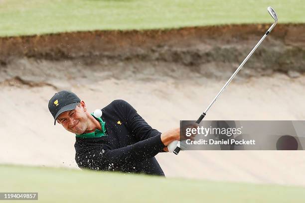 Adam Scott of Australia and the International team plays a shot from a bunker on the eleventh hole during Sunday Singles matches on day four of the...