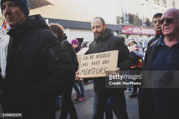Man holding a banner at the demonstration against retirement reform in Nantes, France, 16 January 2020