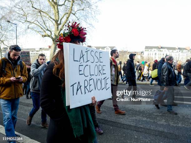 Woman holding a banner calling for revolution, at the demonstration against retirement reform in Nantes, France, 16 January 2020