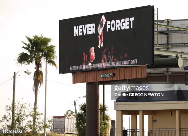 An electronic billboard advertisement paid for by the Florida Democratic Party reading "Never Forget" and showing US President Donald Trump throwing...