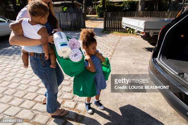 mum and kids unload bags of groceries - australian family car fotografías e imágenes de stock