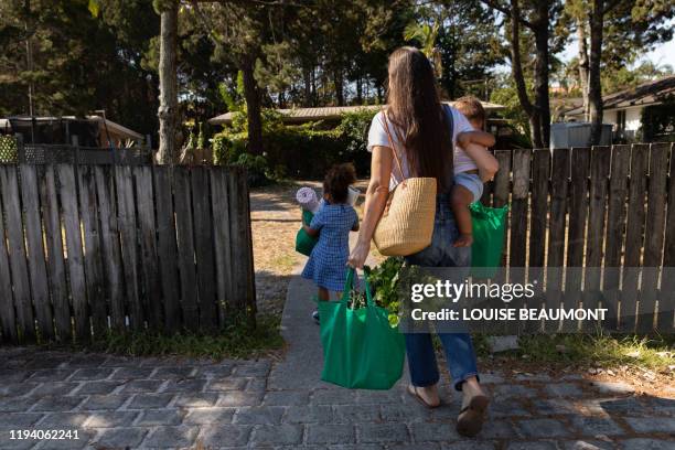 young family reunites after work and school - woman carrying tote bag fotografías e imágenes de stock