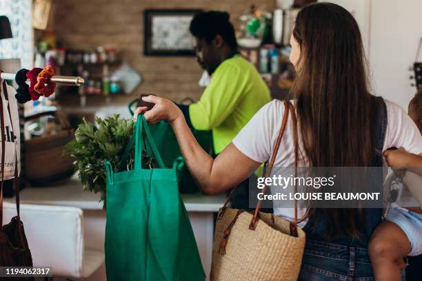bringing in the groceries - young man groceries kitchen stockfoto's en -beelden
