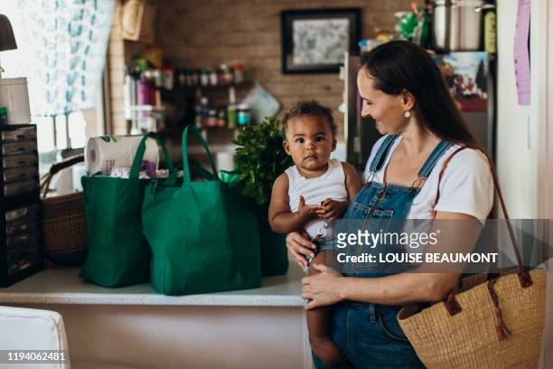 young australian mother and son - picking up groceries stock pictures, royalty-free photos & images