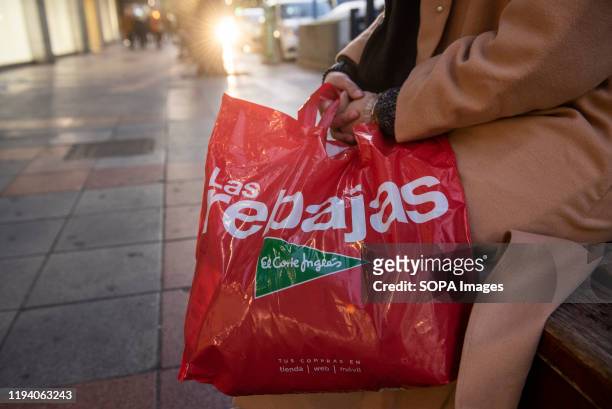 Woman holds a shopping bag with the word "Sale" in Spain.