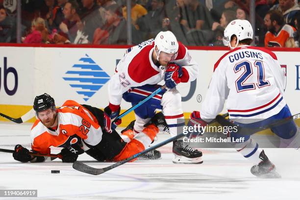 Claude Giroux of the Philadelphia Flyers falls to the ice in front of Dale Weise and Nick Cousins of the Montreal Canadiens in the second period at...