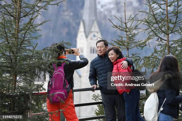 Tourists take photos in the town center on January 16, 2019 in Hallstatt, Austria. Hallstatt, known for its picturesque beauty and its location at...