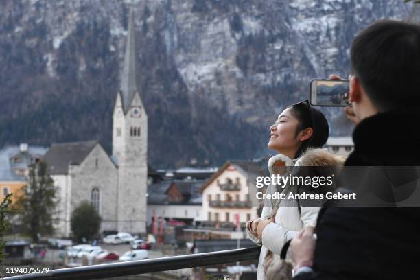 Tourists take photos in the town center on January 16, 2019 in Hallstatt, Austria. Hallstatt, known for its picturesque beauty and its location at...