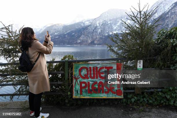 A tourist takes photos in the town center on January 16, 2019 in Hallstatt, Austria. Hallstatt, known for its picturesque beauty and its location at...