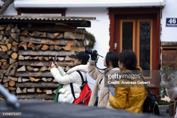 Tourists take pictures in the town center on January 16, 2019 in Hallstatt, Austria. Hallstatt, known for its picturesque beauty and its location at...
