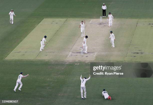 Pat Cummins of Australia celebrates after taking the wicket of Colin de Grandhomme of New Zealand during day four of the First Test match in the...