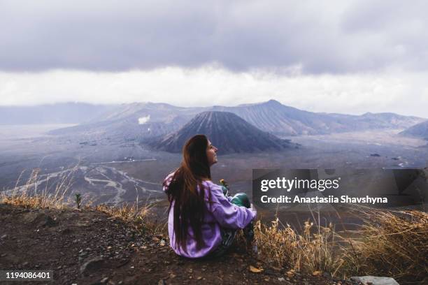 woman enjoying the view of beautiful volcanoes during sunrise at bromo area, indonesia - mount bromo stock pictures, royalty-free photos & images