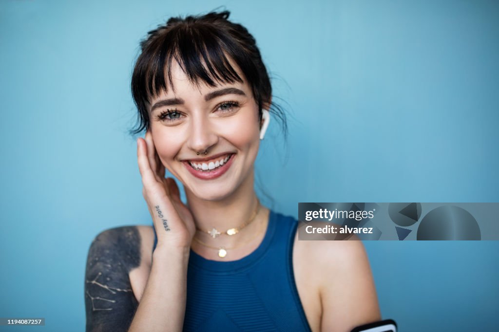 Mujer fitness escuchando música en auriculares inalámbricos