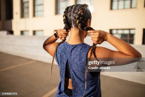 young woman in sports wear standing outdoors - women hairstyle stock pictures, royalty-free photos & images