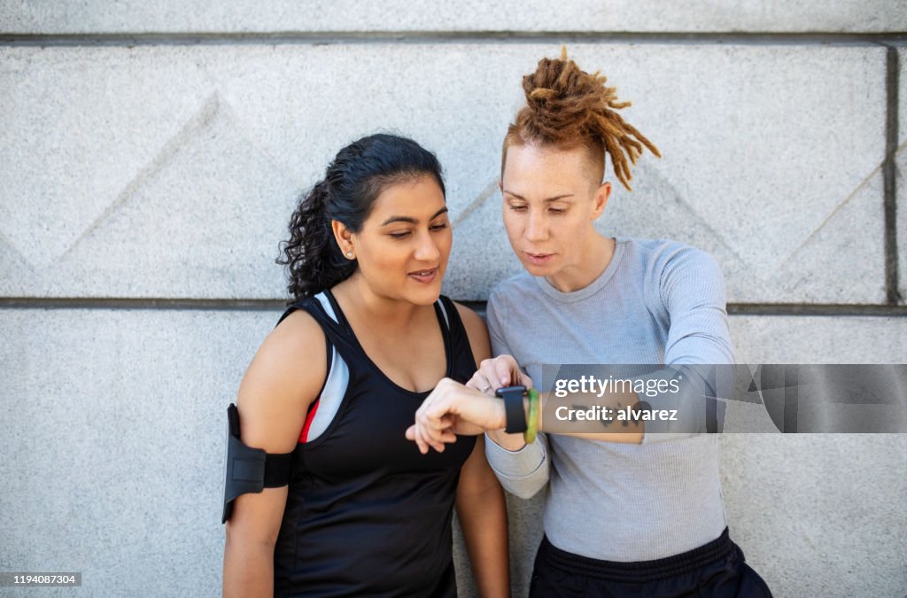 Sporty women checking fitness app on smart watch