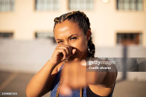 athletic woman in boxing stance outdoors - gym determination stock pictures, royalty-free photos & images