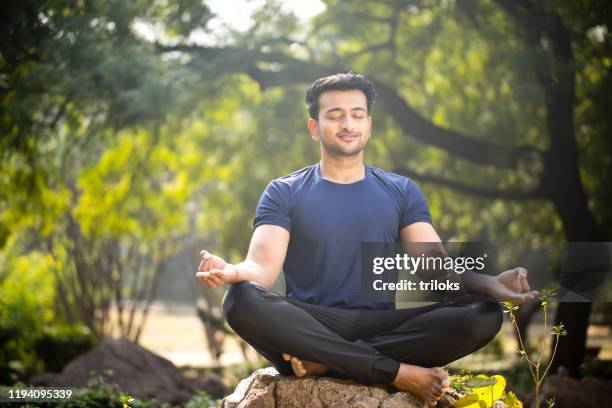 mann meditiert im park - mudra stock-fotos und bilder