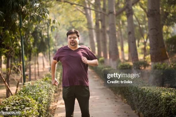 mann männer joggen im park - fat guy running stock-fotos und bilder