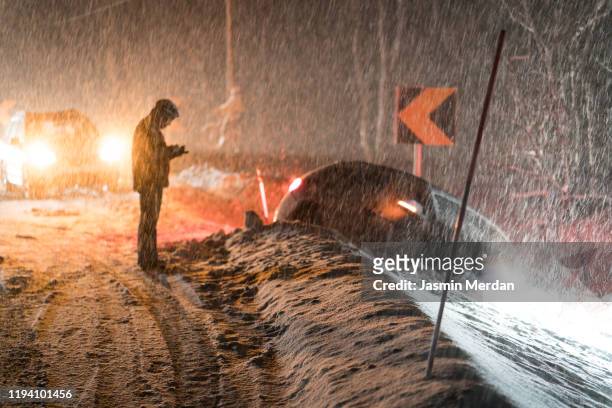 man calling for help for car accident in snow - snow covered road stockfoto's en -beelden