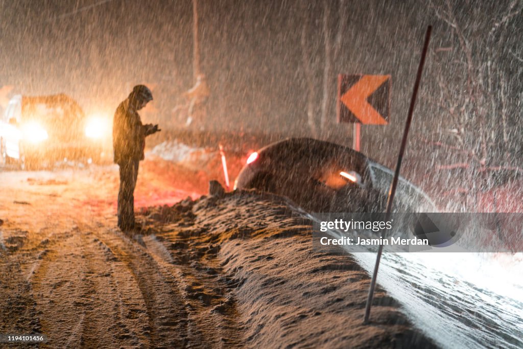 Man calling for help for car accident in snow