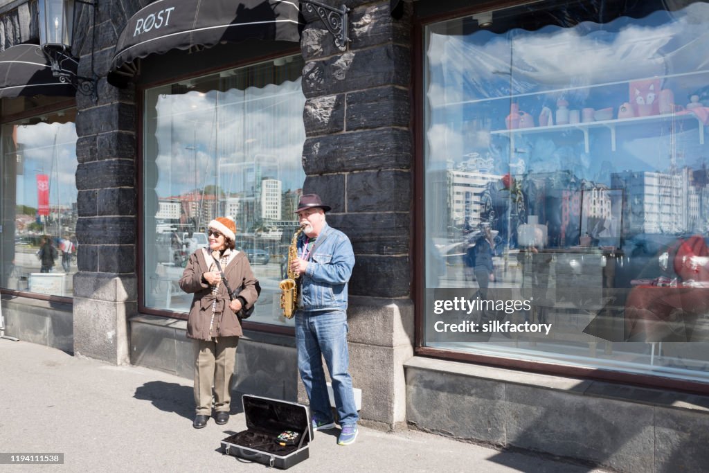 Street musician playing an alto saxophone in City of Bergen on the west coast of Norway on sunny day in spring