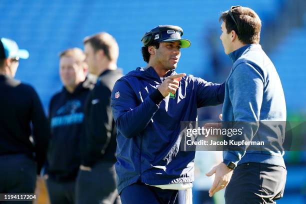 Russell Wilson of the Seattle Seahawks talks with former Carolina Panthers quarterback Jake Delhomme before their game at Bank of America Stadium on...
