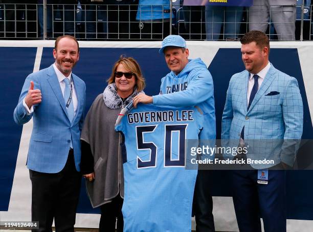 Tennessee Governor Bill Lee receives a Titans jersey from owner Amy Adams Strunk and general manager Jon Robinson prior to a game against the Houston...