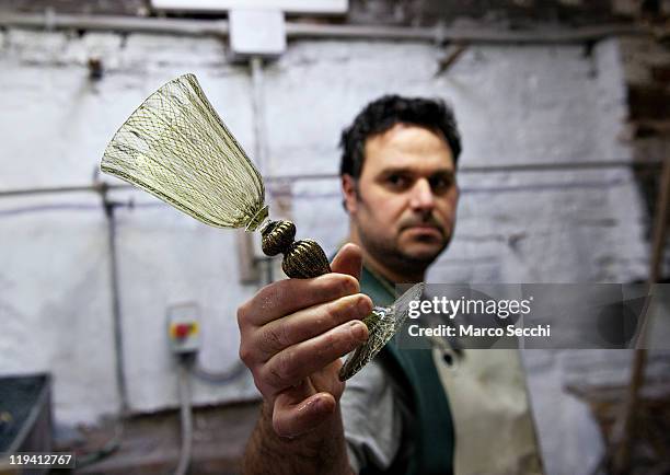 Alessandro Mandruzzato, a glass artisan in Murano, shows an ornate goblet on July 20, 2011 in Venice, Italy.The fall in the number of artisans has...