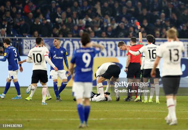 Alexander Nuebel of FC Schalke 04 is shown a red card by referee Felix Zwayer during the Bundesliga match between FC Schalke 04 and Eintracht...