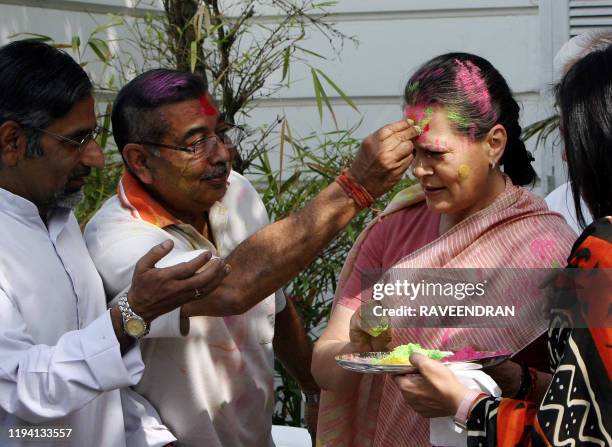 Chairperson of the Congress-led UPA government and Congress Party President Sonia Gandhi is daubed with festive "Holi" colours from party supporters...