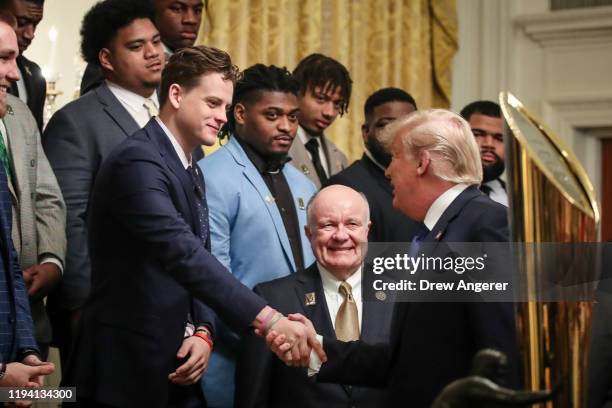 Louisiana State University quarterback Joe Burrow shakes hands with President Donald Trump during an event to honor this year's NCAA football...