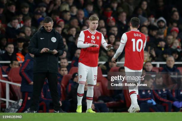 Mesut Ozil of Arsenal is replaced by sub Emile Smith Rowe during the Premier League match between Arsenal FC and Manchester City at Emirates Stadium...