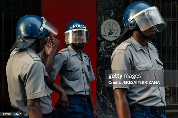 Zimbabwe anti-riot police officers stand guard outside Zimbabwe's main opposition party Movement for Democratic Change headquarters in the capital...