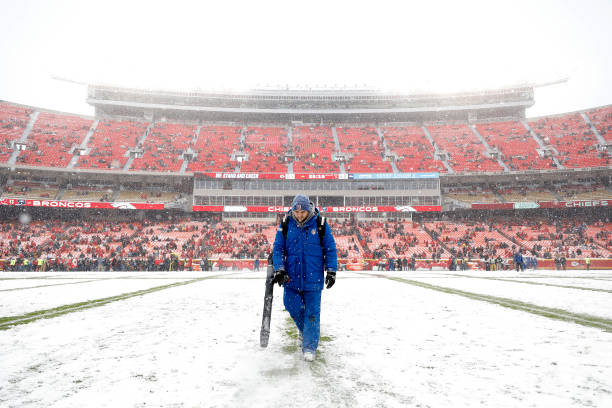 Grounds worker clears snow on the field prior to the game at Arrowhead Stadium between the Kansas City Chiefs and the Denver Broncos on December 15,...