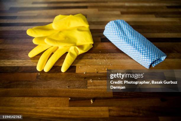 crumbs on a table top, a couple of yellow rubber gloves and a cleaning cloth - spültuch stock-fotos und bilder